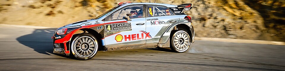 Une voiture de rallye en dérapage sur une route du championnat du monde des rallyes