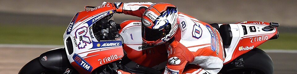 Un pilote sur une moto faisant le tour d'un coin de la piste